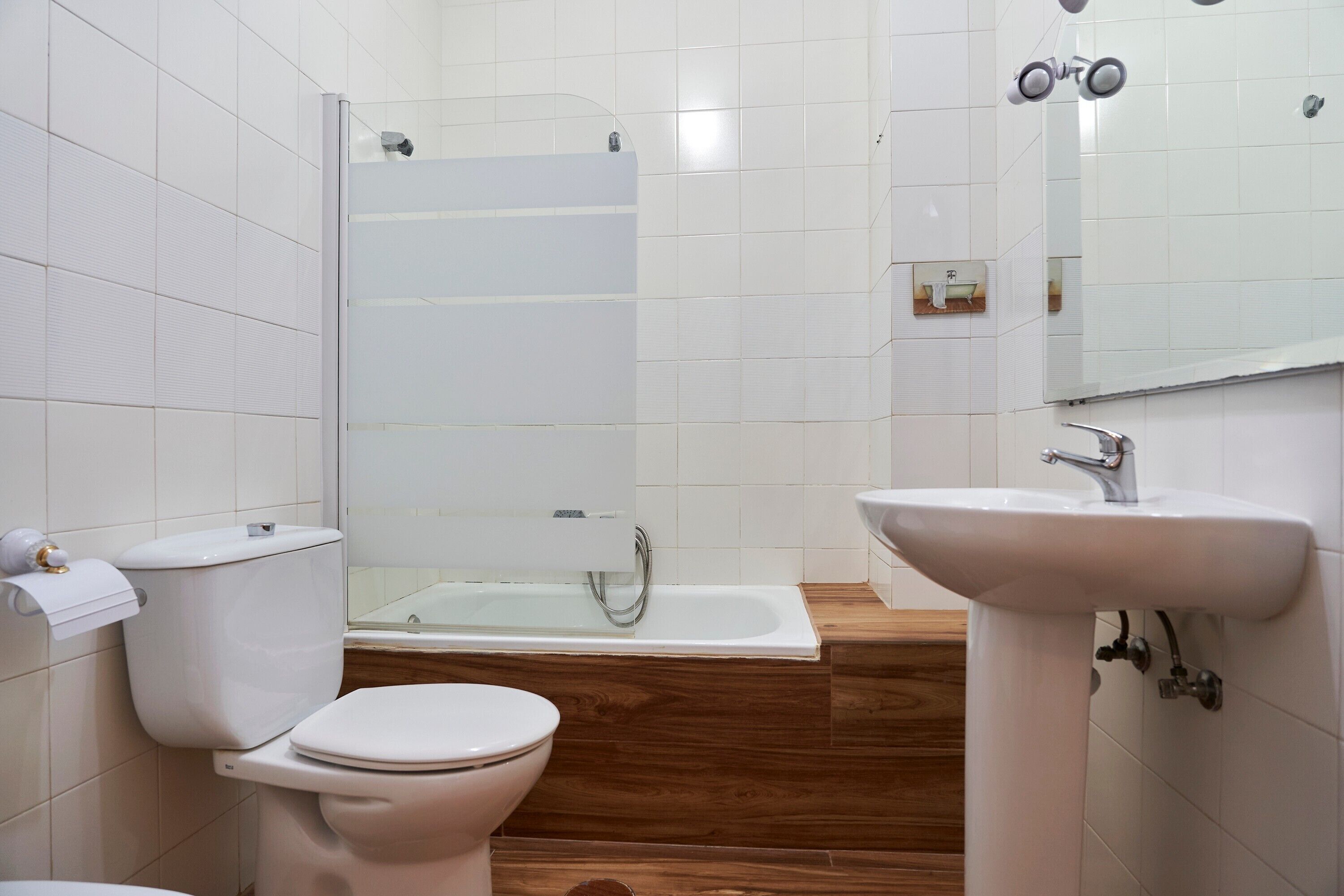 A bathroom with a toilet, a shower, and a sink.