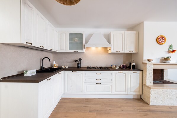 A modern kitchen with white cabinetry, a gas stove, and a built-in oven.