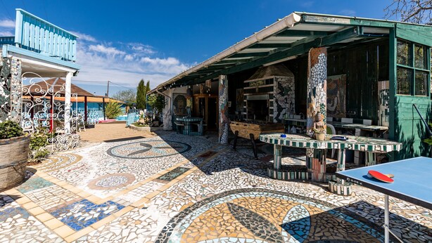 A courtyard with mosaic flooring, outdoor seating, and a ping pong table.