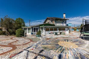A house with a mosaic floor, a green roof, and a chimney. - Holiday Home "Gîte 2 à la Maison Mosaïc" with Shared Pool & Wi-Fi (Gaillan en Medoc)