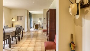 A dining area with a table and chairs, a lamp, a cabinet, and a wall-mounted hat rack. - Holiday Home 'Josi' with Shared Pool, Private Terrace and Wi-Fi (Navata)
