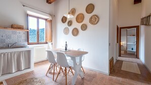 A kitchen with a dining table, chairs, a hanging light, and woven wall decorations. - Farmhouse "Parulia Country House - Gea" with Shared Pool, Shared Terrace & Wi-Fi (Molin Nuovo)