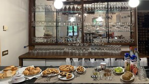 A kitchen counter with a variety of food items, a large window displaying numerous glassware, and hanging pendant lights. - Farmhouse "Parulia Country House - Estia" with Shared Pool, Shared Terrace & Wi-Fi (Molin Nuovo)