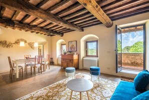 Amplia habitación con comedor, sofá y un amplio ventanal con vistas.