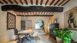 Un coin repas avec une table en bois, des chaises et un tapis à motifs.