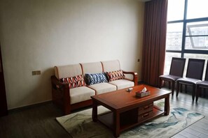 A living room with a sofa, a coffee table, and two chairs. - Xuangui Hotel (Guiding)