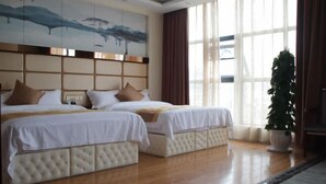 A hotel room with two beds, a large window with curtains, a painting on the wall, and a potted plant. - Xuangui Hotel (Guiding)