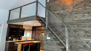 Eine moderne Küche mit einer Holztreppe und einem Glasgeländer.