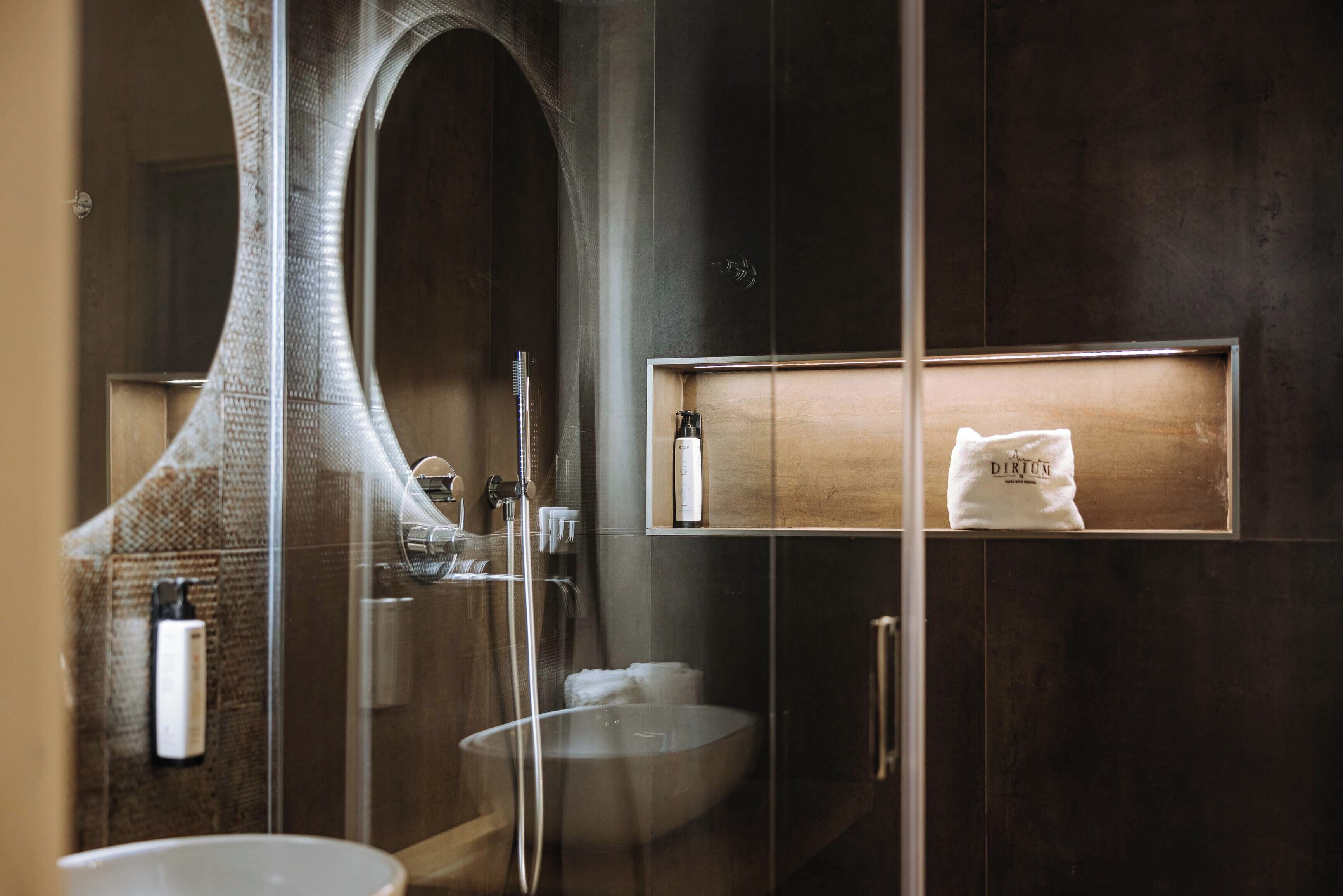 Une salle de bain moderne avec une douche à parois de verre, un grand miroir et un meuble-lavabo en bois.