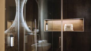 Une salle de bain moderne avec une douche à parois de verre, un grand miroir et un meuble-lavabo en bois.