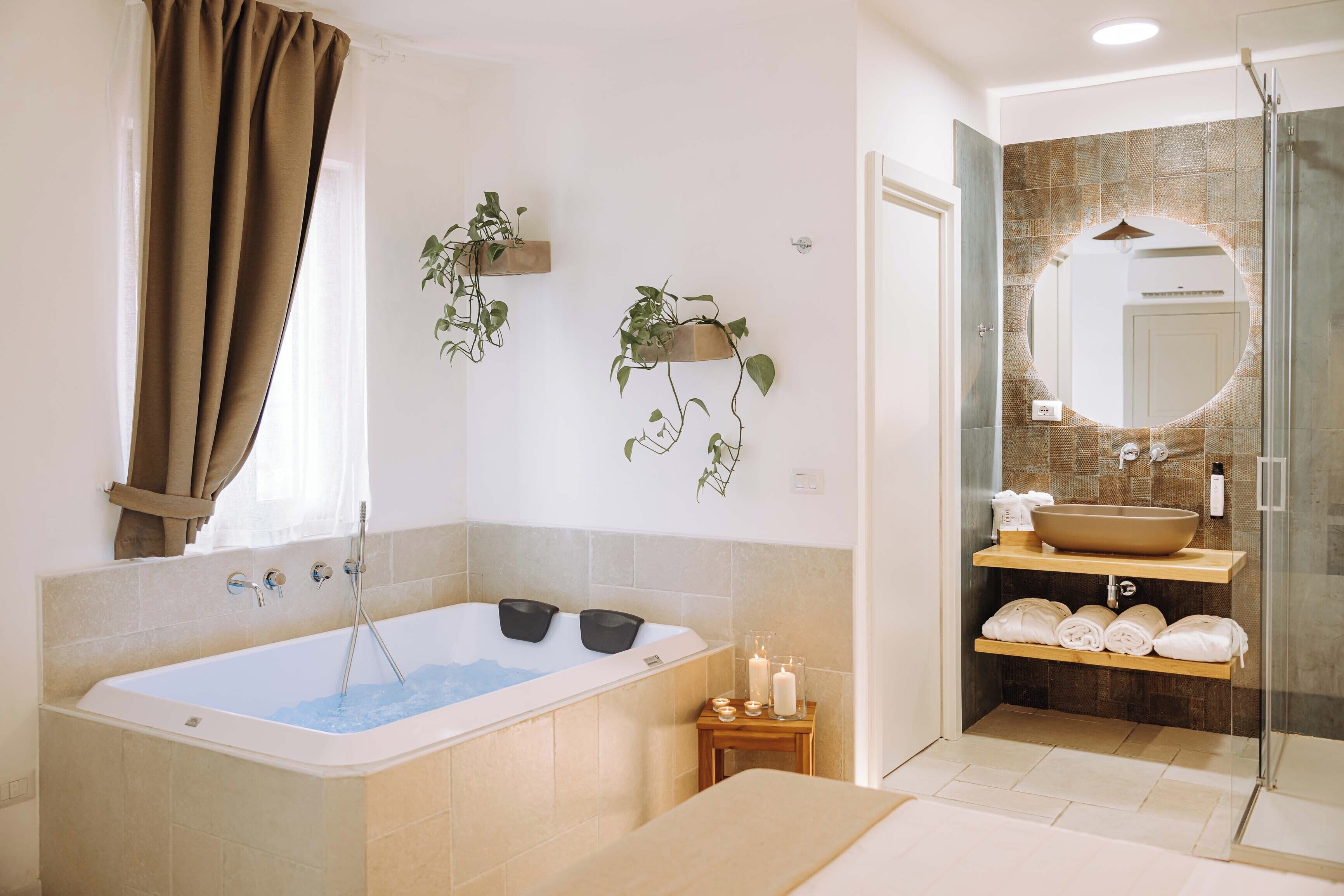 Ein modernes Badezimmer mit freistehender Badewanne, einer Duschkabine und einem Waschtisch mit großem Spiegel.