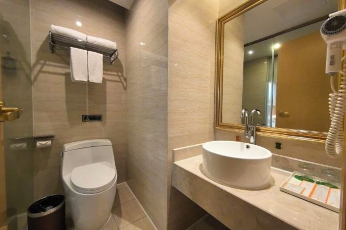 A modern bathroom with a toilet, sink, and a hairdryer.