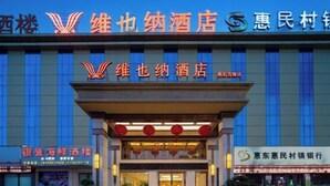 A hotel with a prominent sign indicating it is a '维也纳酒店' (Vienna Hotel). - Vienna Hotel (Huidong Jilong) (Huidong)