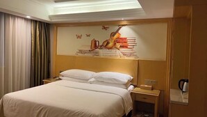 A hotel room with a bed, a nightstand, a coffee maker, and a wall mural of a violin and books.