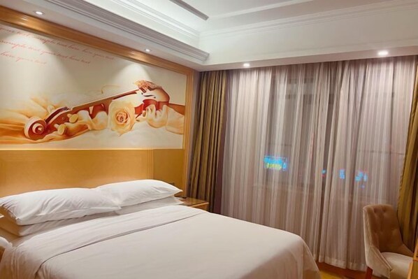 Een hotelkamer met een bed, een stoel, een groot raam met gordijnen en een muurschildering.