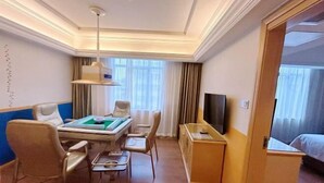 A hotel room with a pool table, a TV, a bed, and a desk with a chair. - Vienna Hotel (Huidong Jilong) (Huidong)