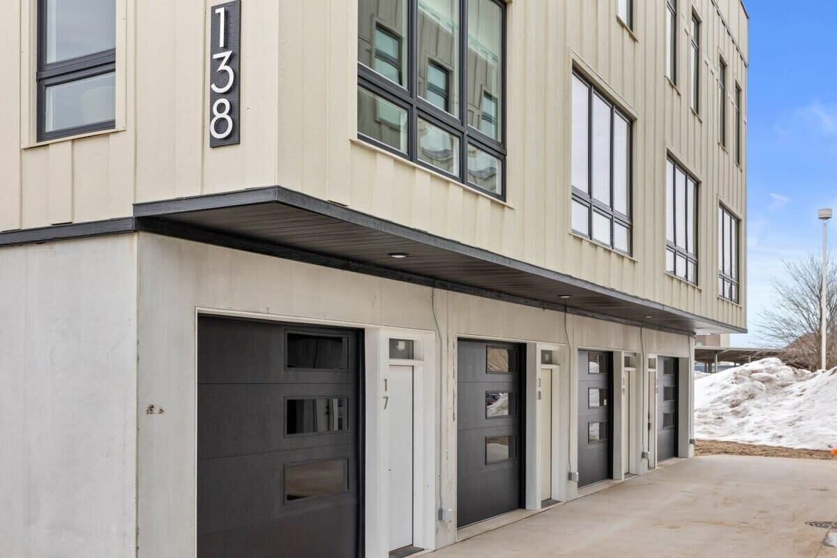 Un bâtiment moderne avec des portes numérotées, de grandes fenêtres et une allée couverte.