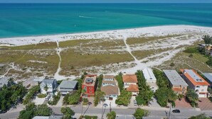 An aerial view of a coastal area with a beach, buildings, and a road. - Bean Point Beachfront- Beachfront 4 bedroom private home with pool/spa (Anna Maria)