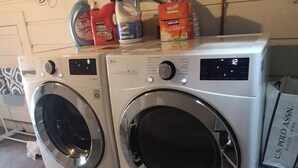 Une machine à laver à chargement frontal, dotée d’un panneau de commande et d’un écran numérique.