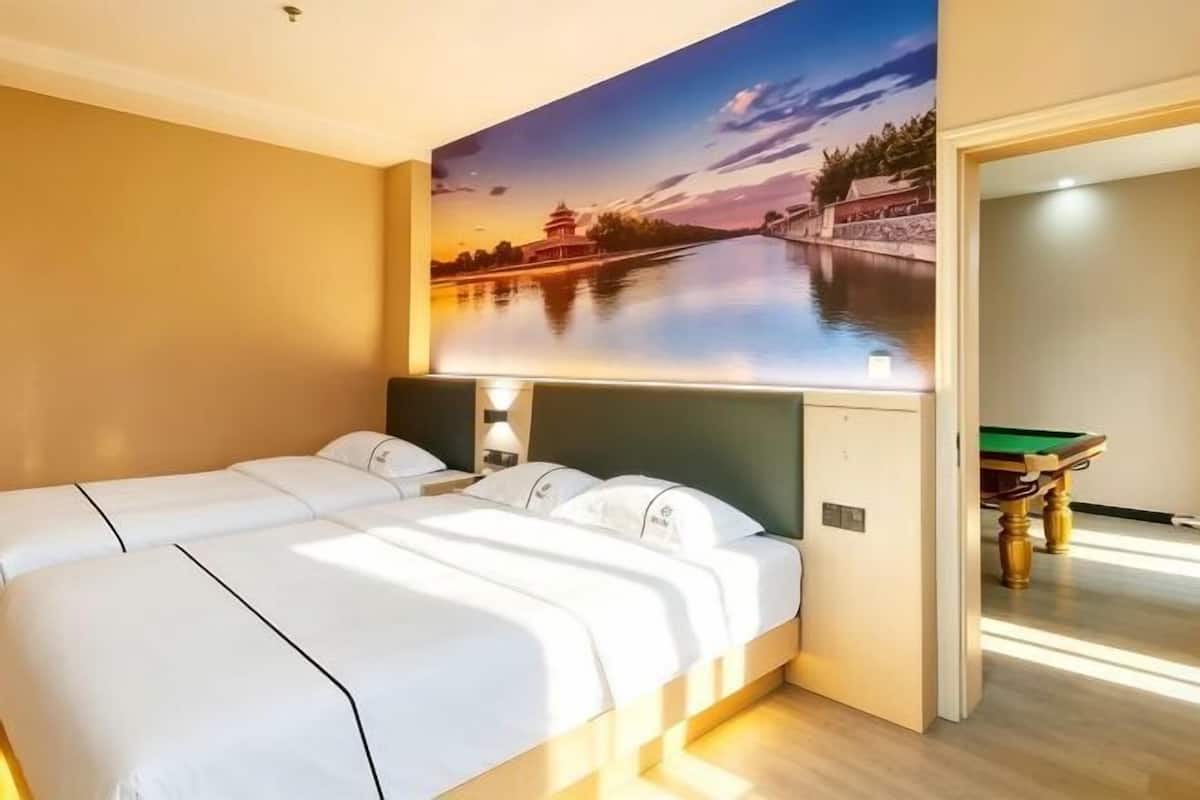 Una habitación de hotel con una cama grande, un televisor montado en la pared y una mesa de billar.