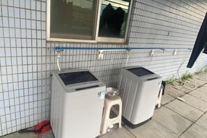 Two large appliances, possibly washers, against a tiled wall with a window above. - Yaduo Hotel (Xinfeng County Yunjishan Scenic Area) (Xinfeng)