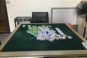 A room with a green felt table for playing mahjong, a black office chair, a whiteboard, and a standing fan. - Yaduo Hotel (Xinfeng County Yunjishan Scenic Area) (Xinfeng)