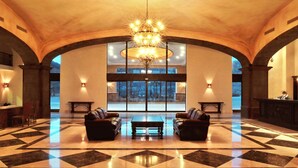 A spacious lobby with a checkered floor, two leather sofas, a chandelier, and large windows offering a view of the outdoors. - Villa Del Palmar Cabo San Lucas (Cabo San Lucas)
