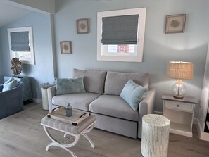 A living room with a sofa, a coffee table, a lamp, and a side table.