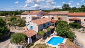 A villa with a swimming pool, stone walls, and terracotta roofs. - Typical Istrian stone house with garden, pool and sauna, Pets are welcome. (Sveti Lovrec)