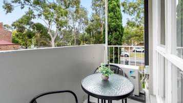 Enjoy a peaceful retreat on your balcony with a glass-top table and comfortable seating for two.