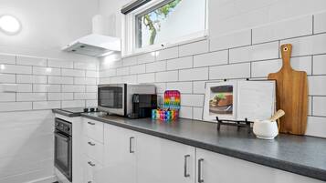 Enjoy cooking in this well-equipped kitchen with a window offering a view of the surrounding trees.