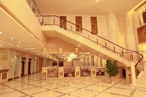 A spacious lobby with a grand staircase, polished floors, and a reception desk. - Doudu Business Hotel (Nenjiang)