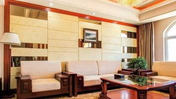 A room with a sofa, a coffee table, a lamp, and a large mirror.