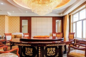 A conference room with a round table, chairs, and a chandelier.