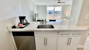 Una cucina moderna con lavastoviglie, macchina da caffè e lavello.