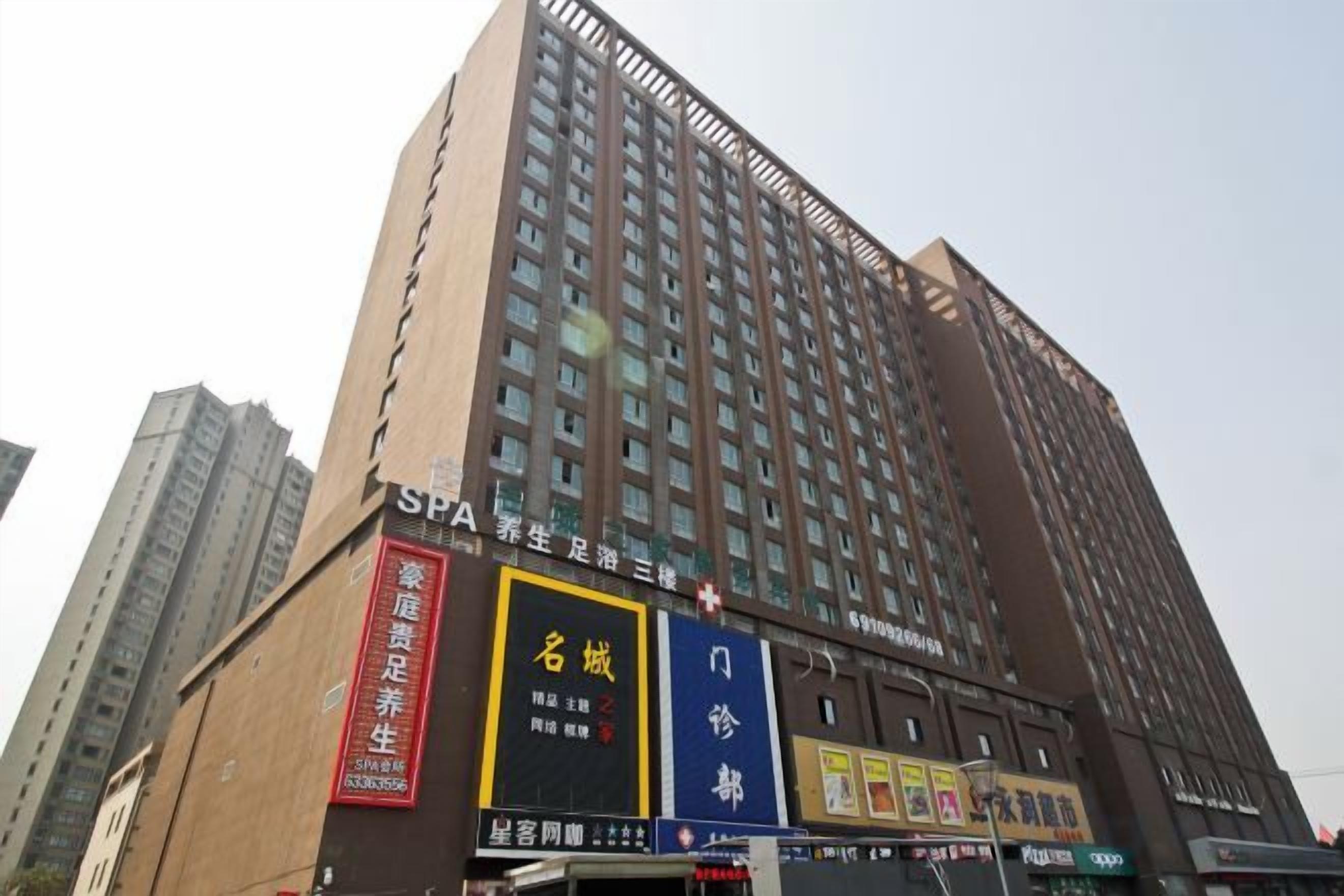 Un hotel alto con diversi piani, con un cartello ben visibile per una spa e una vetrina che mostra vari annunci pubblicitari.