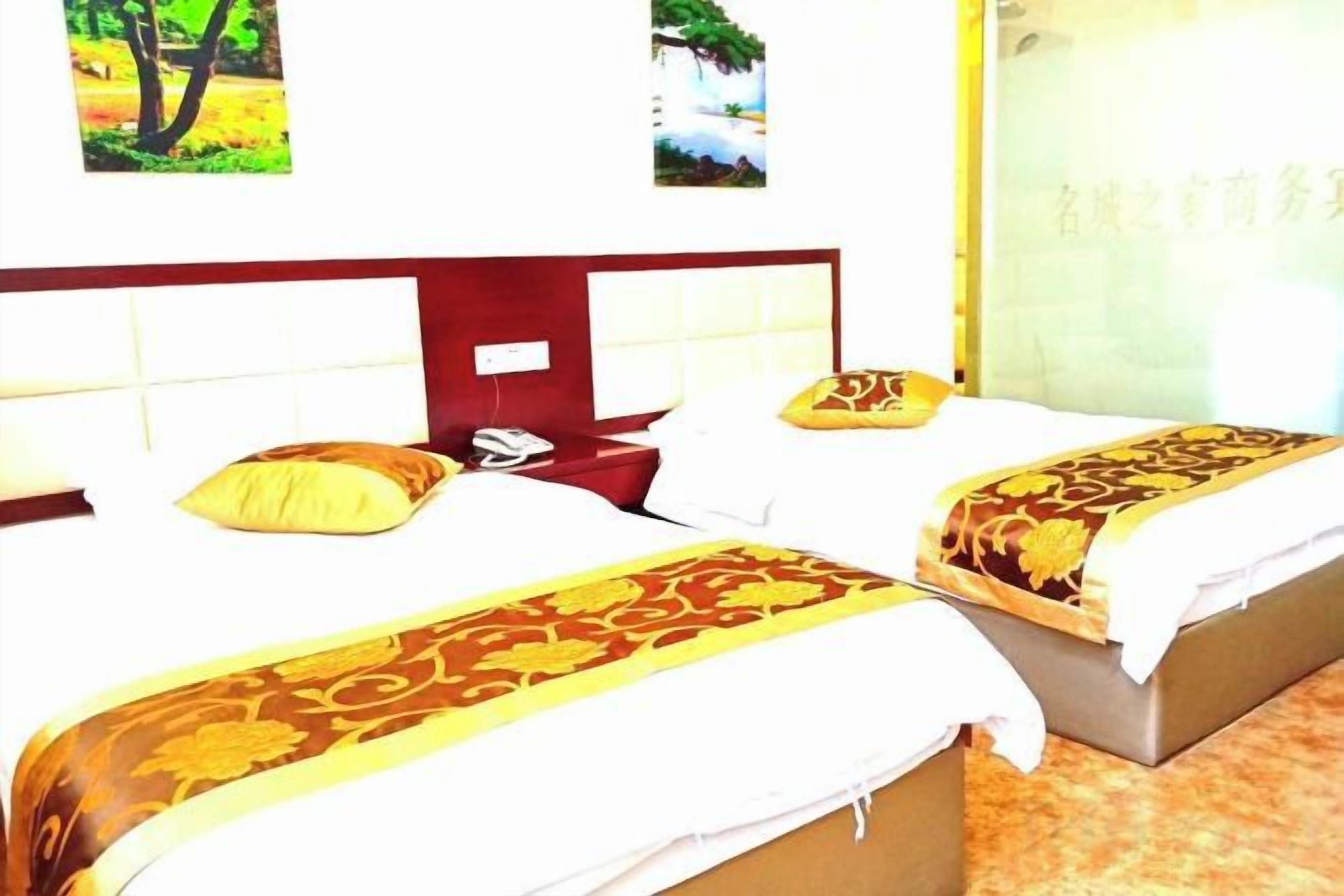 Habitación de hotel con dos camas, cada una con una colcha estampada, cabecero de madera y mesita de noche.