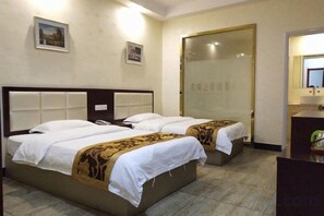 A hotel room with two beds, a bathroom with a mirror, and a small desk. - Mingcheng Home Business Hotel (Hefei)