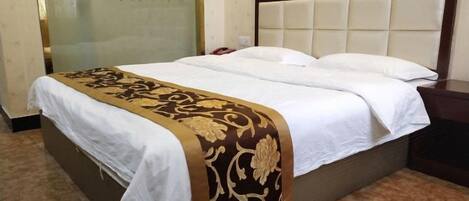 A hotel room with a bed, a bedside table, and a wall with a decorative panel.