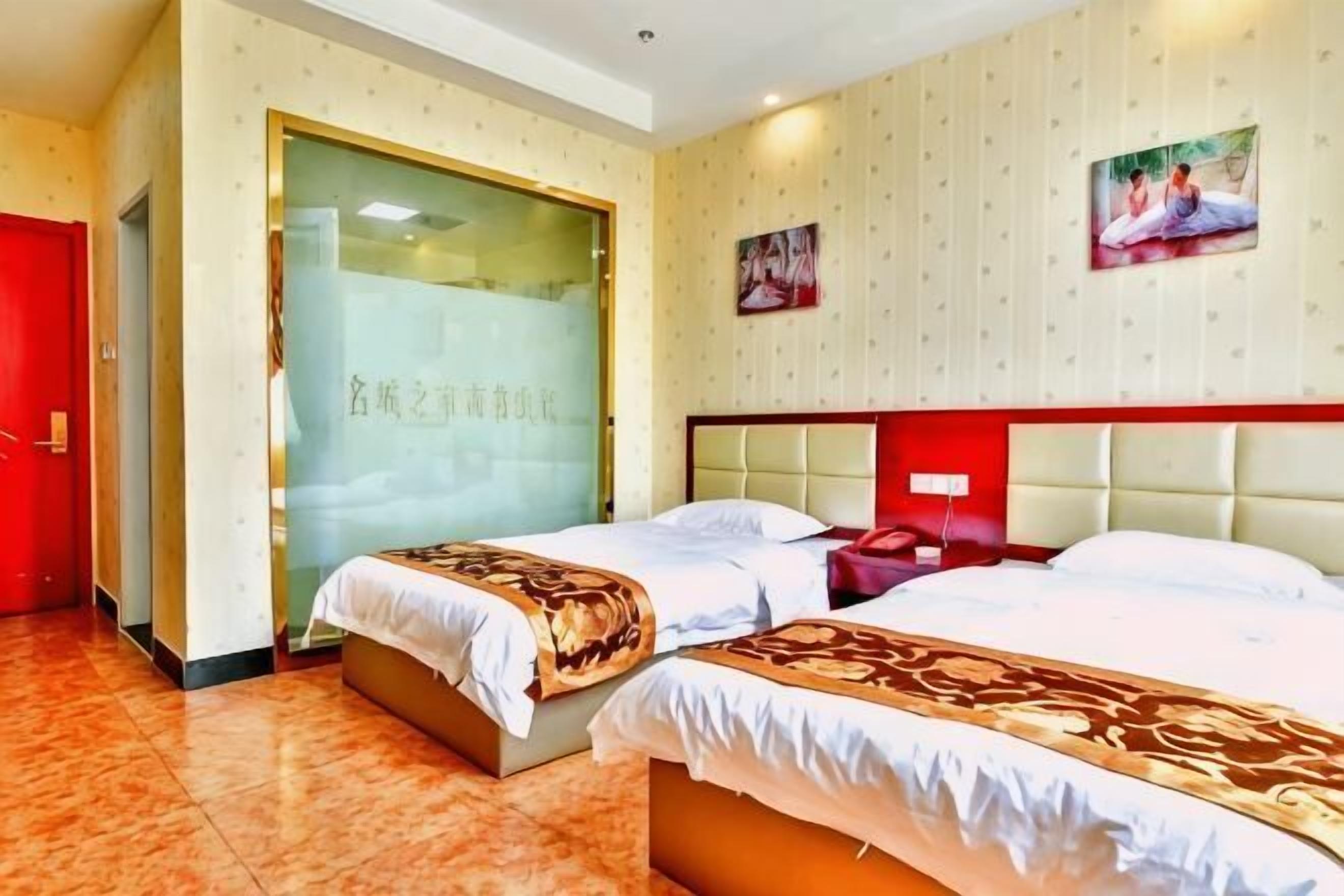 A hotel room with two beds, a red door, a glass wall, and a patterned wall.
