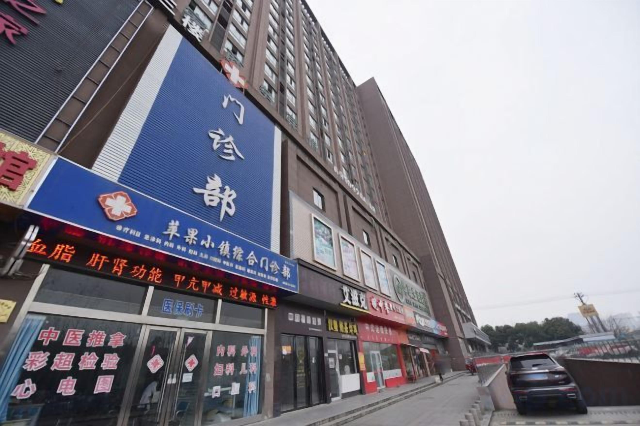 Edifício comercial com várias lojas, incluindo uma grande placa azul com caracteres chineses.