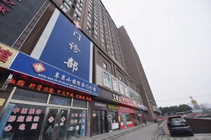 A commercial building with multiple storefronts, including a large blue sign with Chinese characters.
