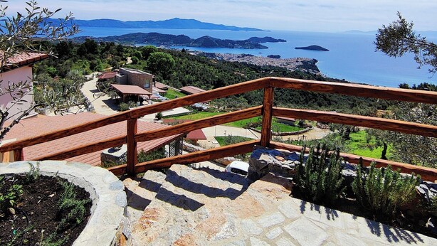 A stone staircase leading to a terrace with a wooden railing, overlooking a coastal landscape with mountains and a clear sky. - Small Villa Emy Exclusive (Sporades)