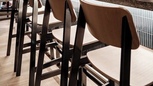 Un bar moderno con sillas de madera e iluminación colgante.