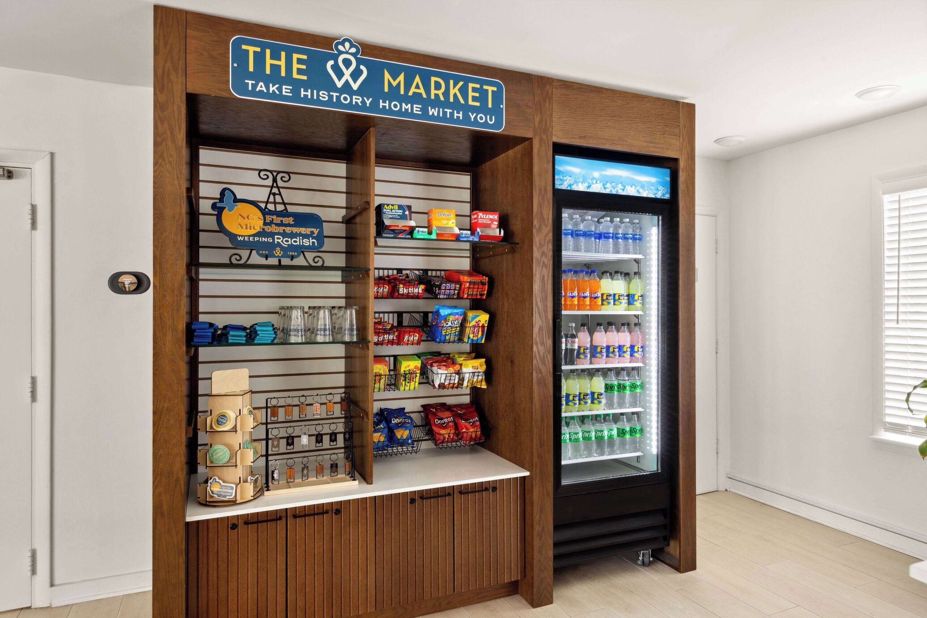 A small market kiosk with a wooden facade, stocked with snacks and beverages, and a refrigerator filled with drinks.
