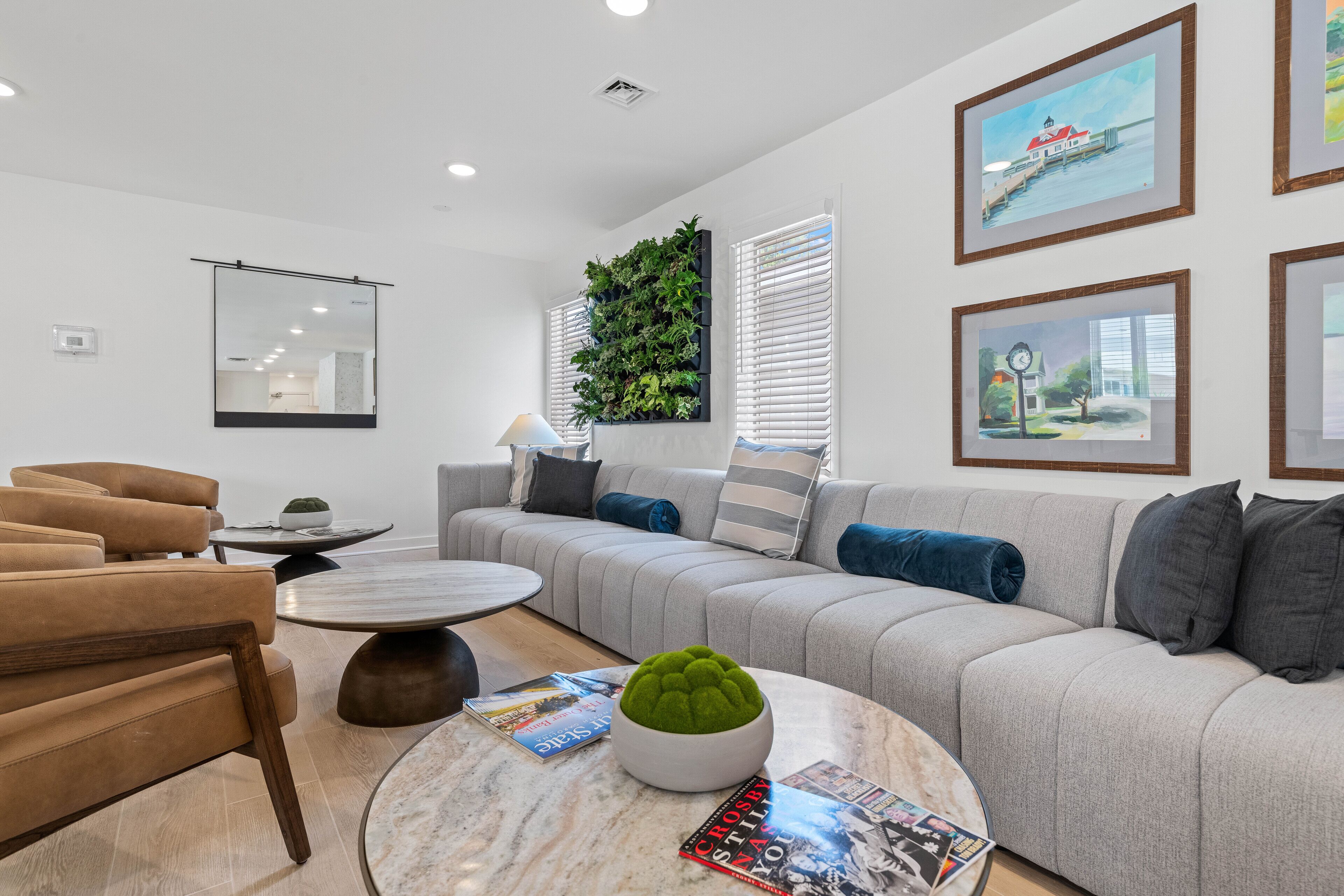 A modern living room with a grey sofa, a round coffee table, and a green decorative item.