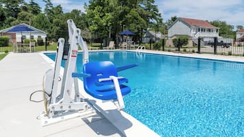 Ein Schwimmbecken mit Sprungbrett und Rettungsschwimmerstuhl.
