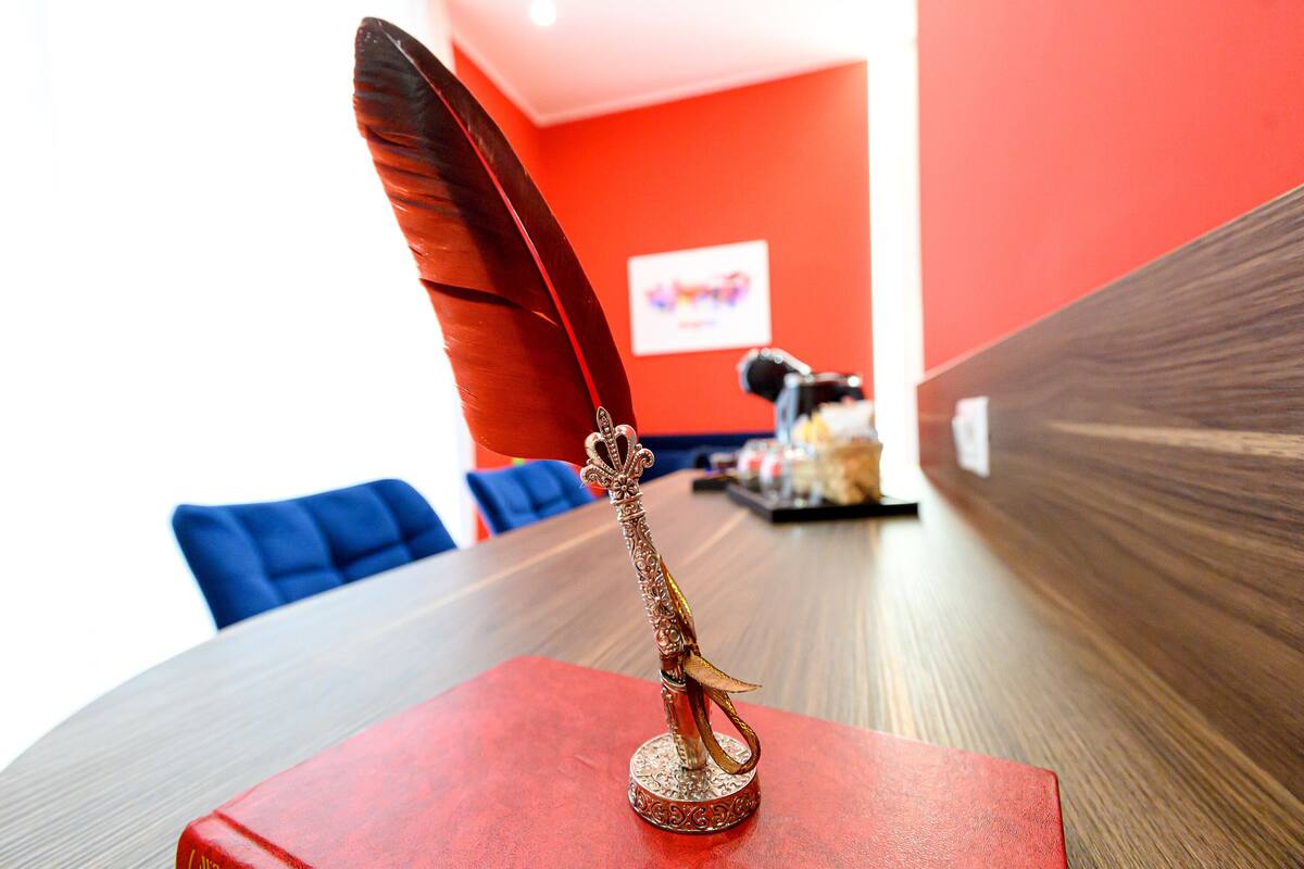 A table with a decorative pen holder on a red book.