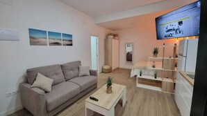 Ett modernt vardagsrum med en soffa, ett soffbord och en tv som är monterad på väggen.