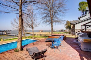 A deck with a pool, outdoor seating, and a grill area. - Cedar Creek Lakefront Vacation Rental w/ Pool (Gun Barrel City)